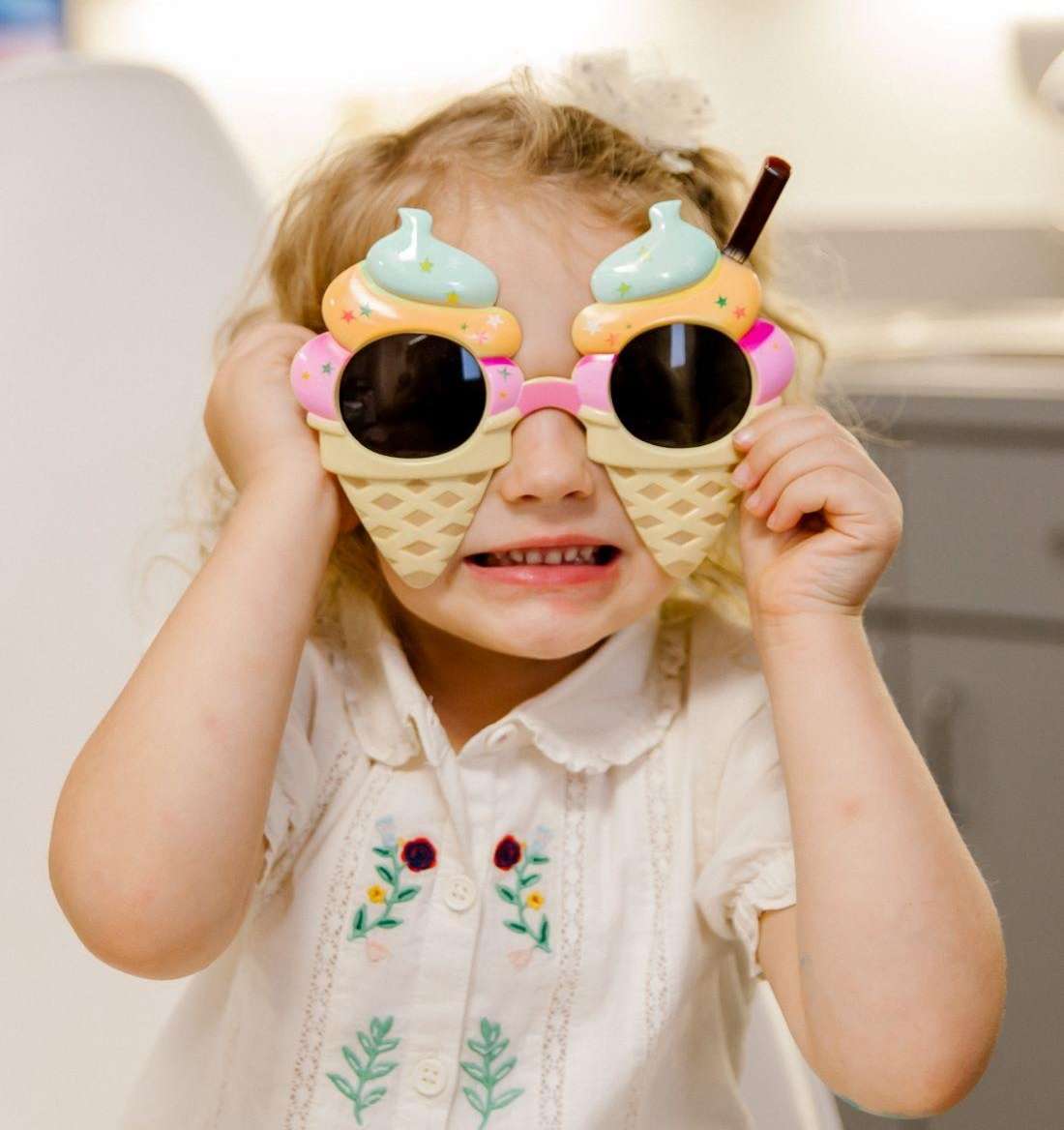 young girl wearing sunglasses at krewe of smiles in metairie