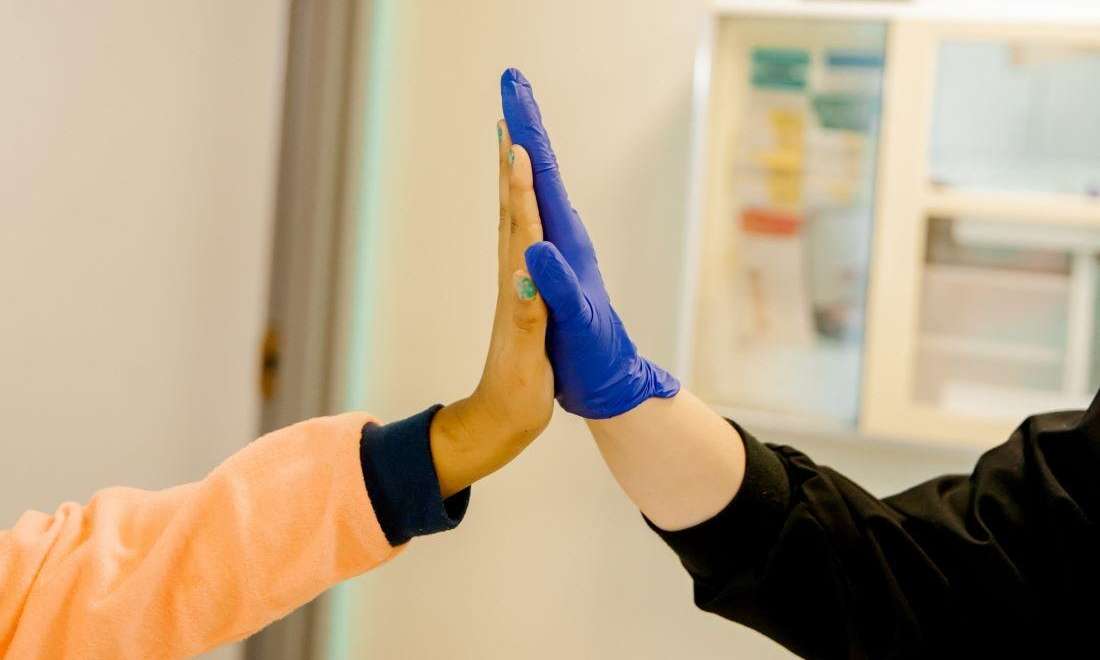 Dr. Christen Massey high fiving a patient at Krewe of Smiles in Metairie 
