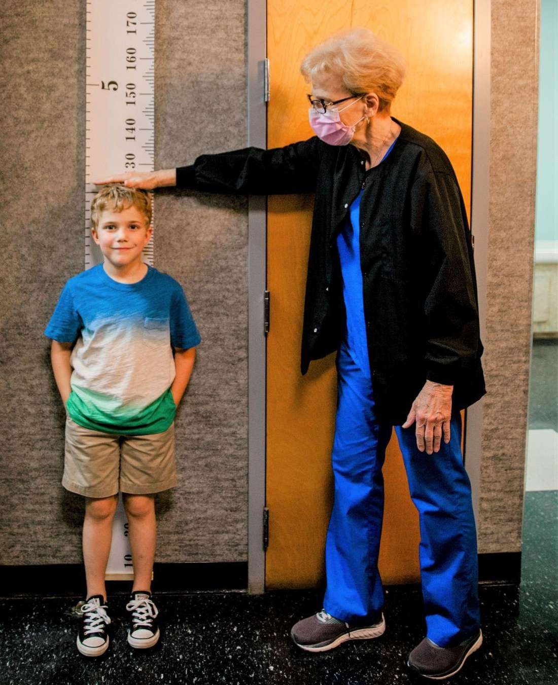 krewe of smiles patient measuring his height 